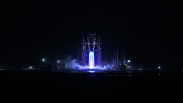 SpaceX Raptor engine nozzle glowing blue during a night static fire test